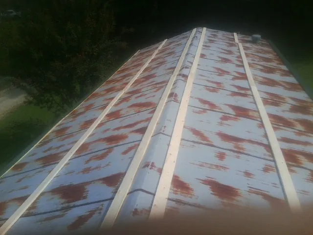 Rusted metal roof panels with new wood purlins before replacement — Storm Damage Roof Repair in Weldona by Roofing Brothers
