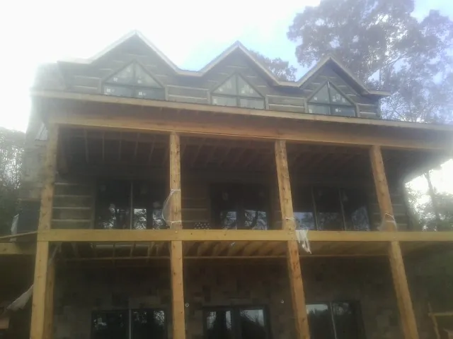 Dormers and porch framing on a large log home under construction — Roof Coating work by our crew in Weldona