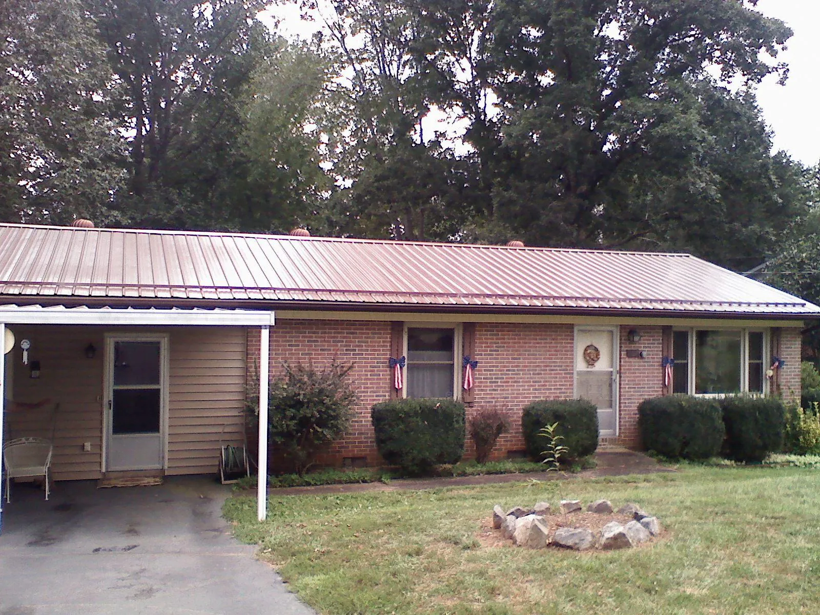 Bronze metal roof and carport on a brick ranch home — Roof Repair work by our crew in Weldona